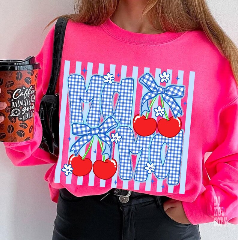 May include: A bright pink sweatshirt featuring the word "MOM" in a blue gingham pattern with red cherries and blue bows. White flowers and vertical stripes accent the design. The sweatshirt is a vibrant, eye-catching piece.