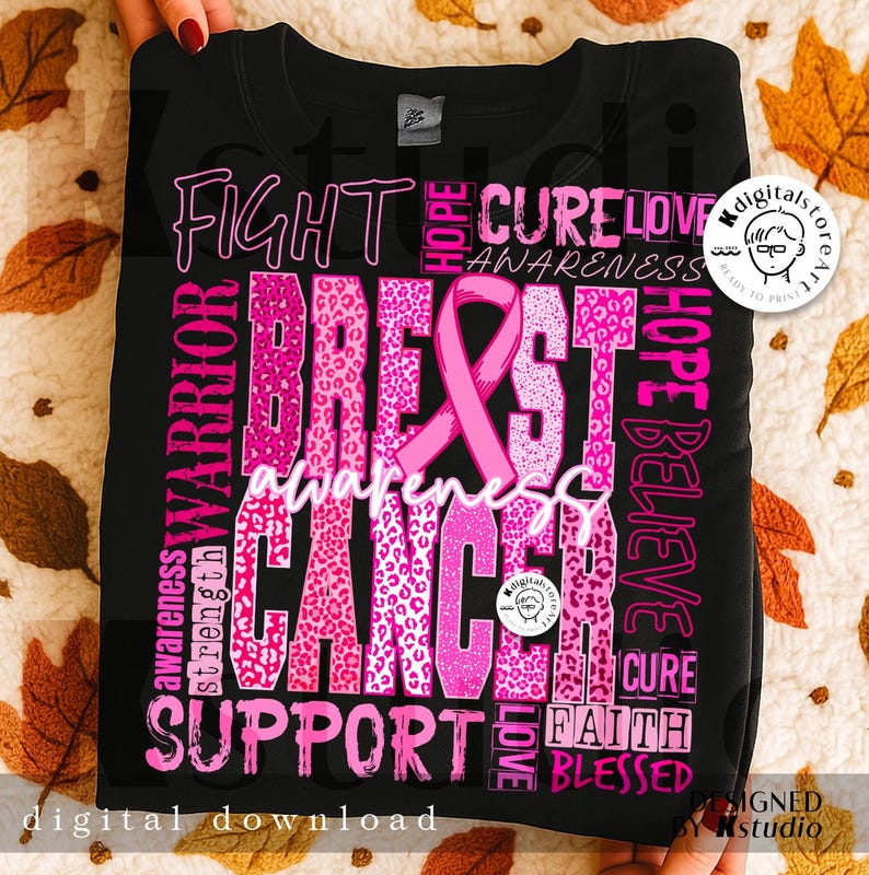 Op de afbeelding: Zwart sweatshirt met een roze design voor borstkankerbewustzijn. Het ontwerp bevat de woorden "Fight, Cure, Love, Awareness, Breast Cancer, Support, Hope, Believe, Faith, Blessed" en een roze lint.