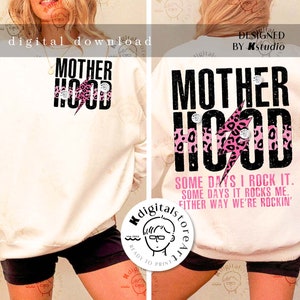 May include: White sweatshirt with black text that reads "Motherhood" with a pink and black leopard print lightning bolt design. The text "Some days I rock it. Some days it rocks me. Either way we're rockin'" is printed below the design.