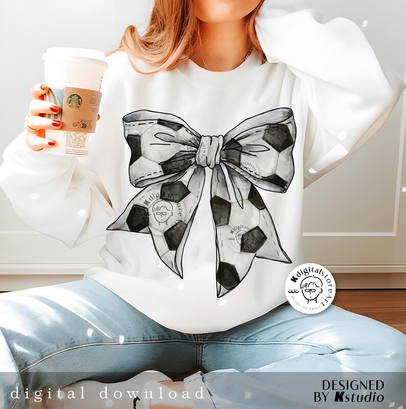 May include: A white sweatshirt with a black and white watercolor soccer ball bow design. The sweatshirt is being worn by a person. The design includes the text "Digitalstore" in a circle.