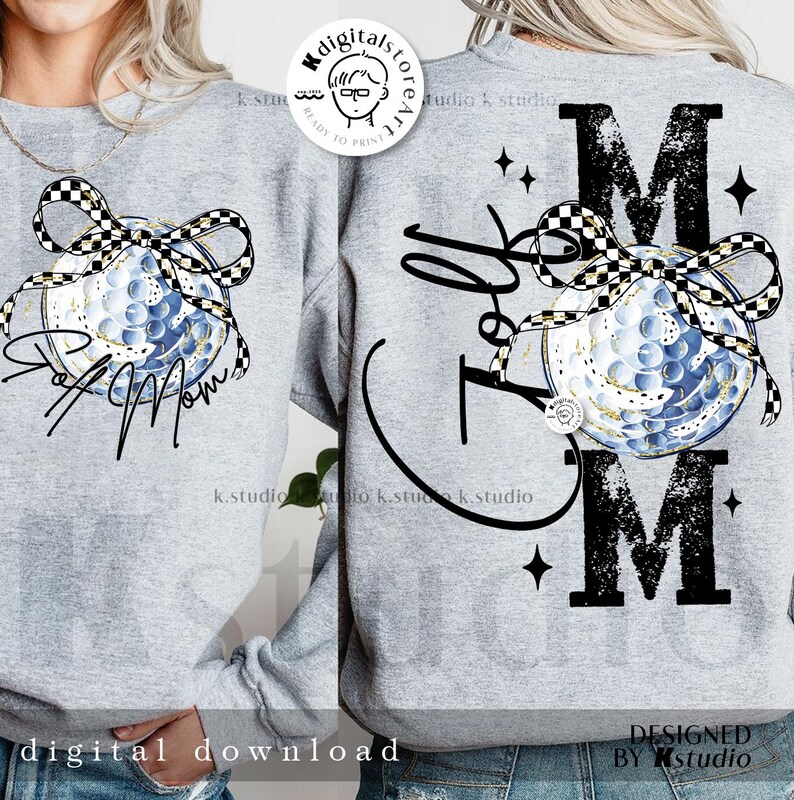 May include: A light gray sweatshirt featuring a golf ball design with a black and white checkered bow. The front of the shirt says "Golf Mom" in black script. The back of the shirt says "Golf Mom" with the letter "M" on top and bottom.