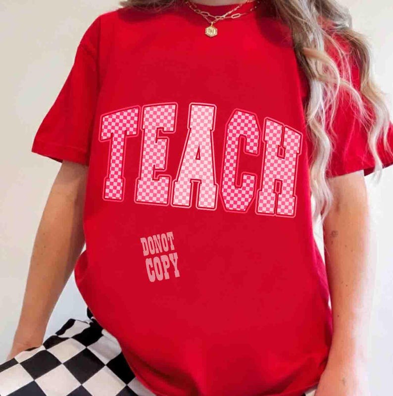 K&ouml;nnte beinhalten: Ein rotes T-Shirt mit dem Wort "TEACH" in gro&szlig;en, wei&szlig; karierten Buchstaben auf der Vorderseite. Darunter steht der Text "DONOT COPY" in kleineren, wei&szlig;en Buchstaben. Das Shirt ist kurz&auml;rmlig.