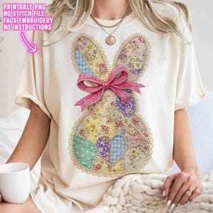 Op de afbeelding: Cr&egrave;mekleurig T-shirt met een patchwork konijnontwerp van bloemen- en patroonstoffen. Het konijn heeft een roze strik en kanten rand. De tekst "PRINTABLE PNG NO STITCH FILE FAUX EMBROIDERY NO INSTRUCTIONS" is op de shirt gedrukt.