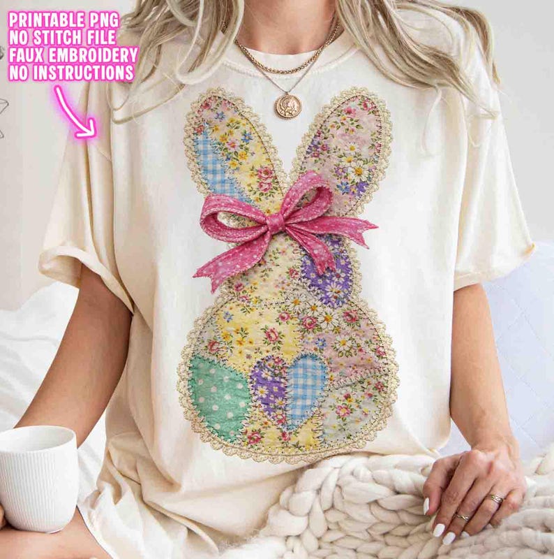 Op de afbeelding: Cr&egrave;mekleurig T-shirt met een patchwork konijnontwerp van bloemen- en patroonstoffen. Het konijn heeft een roze strik en kanten rand. De tekst "PRINTABLE PNG NO STITCH FILE FAUX EMBROIDERY NO INSTRUCTIONS" is op de shirt gedrukt.