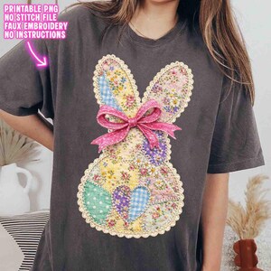 Op de afbeelding: Donkergrijs T-shirt met een patchwork konijn ontwerp met bloemen- en ruitpatronen. Het konijn heeft een roze lint en een geschulpte kanten rand. De tekst op het shirt luidt "PRINTABLE PNG, NO STITCH FILE, FAUX EMBROIDERY, NO INSTRUCTIONS".