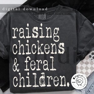 May include: A dark gray t-shirt with white text that reads "raising chickens & feral children."