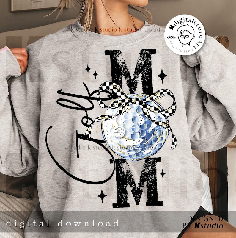 May include: A light gray sweatshirt with a graphic design featuring the word "Mom" in large, distressed black letters. A golf ball with a checkered bow is in the center. The words "Golf Mom" are written in a cursive font. The words "digital download" are at the bottom.