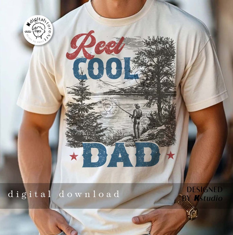 以下が含まれることがあります： 白地に、ヴィンテージスタイルのグラフィックデザインが施されたTシャツ。湖の風景、釣り人、木々、そして「Reel Cool Dad」という文字が赤、青、白で描かれています。