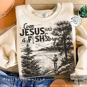 May include: A cream-colored sweatshirt with a black and white graphic design of a lake scene with a fisherman. The text "Even Jesus Had a Fish Story" is printed on the sweatshirt.