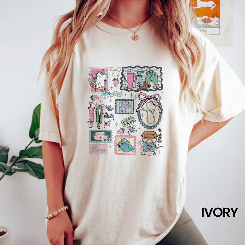 Op de afbeelding: Ivoor kleurig T-shirt met een kleurrijke collage van medische illustraties. Het ontwerp bevat postzegels met afbeeldingen van medische hulpmiddelen, een stethoscoop en een koffiekopje. Het woord "Nurse" is ook zichtbaar. Het shirt heeft korte mouwen.