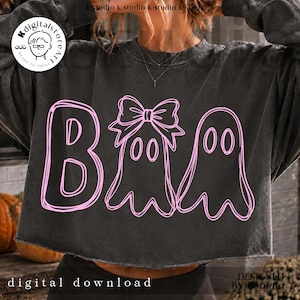 May include: A charcoal gray cropped sweatshirt featuring a light pink graphic design of the word Boo, where the letter o is replaced by a ghost wearing a bow and a second ghost. The text k.digitalstoreart is visible in the top left corner.