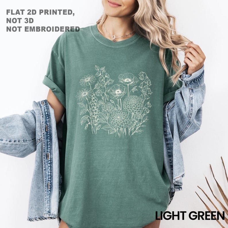 May include: Light green t-shirt with a white floral design. The shirt has rolled-up sleeves and the text "LIGHT GREEN" at the bottom. The text "FLAT 2D PRINTED, NOT 3D, NOT EMBROIDERED" is at the top.