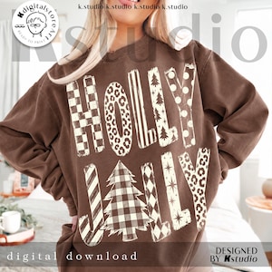 May include: A brown crewneck sweatshirt featuring the text HOLLY JOLLY in large, cream-colored letters. Each letter displays a unique pattern, including checkerboard, leopard print, stripes, polka dots, and a buffalo plaid Christmas tree.