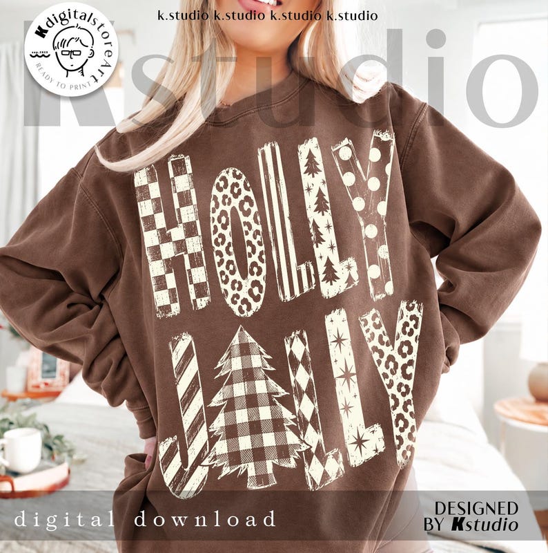 May include: A brown crewneck sweatshirt featuring the text HOLLY JOLLY in large, cream-colored letters. Each letter displays a unique pattern, including checkerboard, leopard print, stripes, polka dots, and a buffalo plaid Christmas tree.