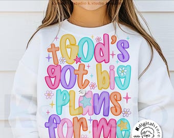 May include: White sweatshirt with the text "God's got big plans for me" in colorful bubble letters. The design includes flowers and stars. The words "digital download" and "designed by Kstudio" are also visible.