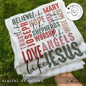 May include: A stack of white t-shirts with various phrases printed in a mix of colors, including red, green, and brown. The phrases include "BELIEVE like MARY", "TRUST like JOSEPH", and "LOVE ANGELS". The words "digital download" and "DESIGNED BY Kstudio" are also visible.