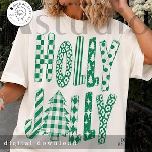 May include: An off-white short-sleeve t-shirt featuring the green text HOLLY JOLLY. The letters are filled with various patterns including green and white checkers, leopard print, stripes, Christmas trees, polka dots, and stars.
