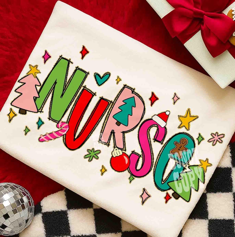 May include: Cream-colored sweatshirt with the word "NURSE" in colorful, festive lettering. The letters are decorated with Christmas-themed illustrations, including a candy cane, Christmas trees, and a gingerbread person. The design is surrounded by stars and diamonds.