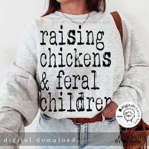 May include: A gray sweatshirt with the text "raising chickens & feral children" printed in black.
