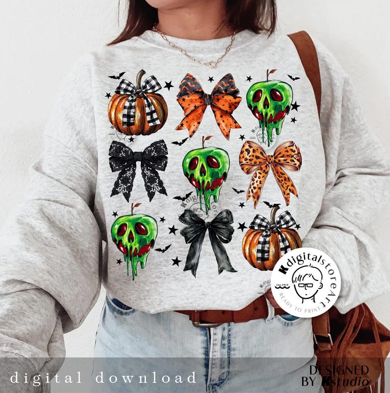 May include: A light gray sweatshirt featuring a Halloween-themed design. The design includes illustrations of pumpkins, bows, and green apples with dripping green goo. The words "digital download" are printed at the bottom.