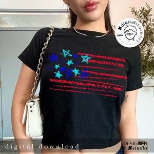 May include: A black t-shirt with a red, white, and blue American flag design. The stars on the flag are drawn in blue, turquoise, and black. The flag is distressed and has a grunge look. The t-shirt is a cropped style.