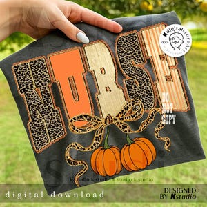 May include: Dark gray t-shirt with the word "NURSE" in a fall-themed design. The letters feature leopard print, orange, and gold accents, with two orange pumpkins and a leopard print bow. The text "digital download" is at the bottom.