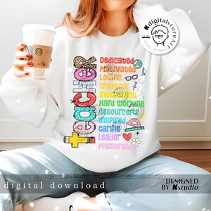 May include: A white sweatshirt with a colorful graphic design that spells out "Teacher" with words describing the qualities of a teacher, such as "dedicated", "motivated", "loving", "creative", "intelligent", "hard working", "resourceful", "inspired", "caring", "leader", and "memorable".