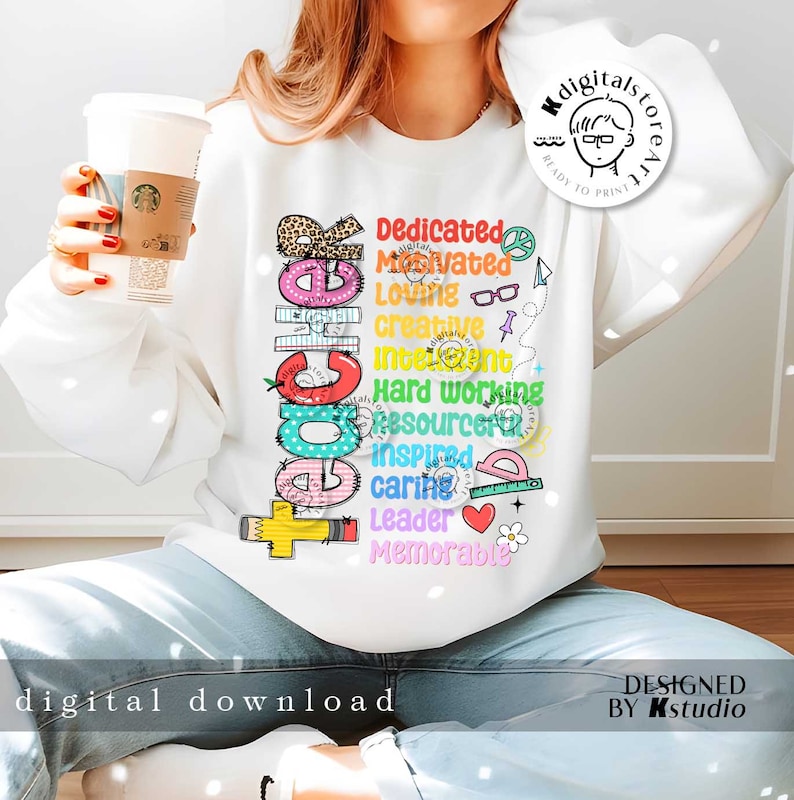 May include: A white sweatshirt with a colorful graphic design that spells out "Teacher" with words describing the qualities of a teacher, such as "dedicated", "motivated", "loving", "creative", "intelligent", "hard working", "resourceful", "inspired", "caring", "leader", and "memorable".