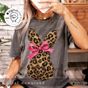 Peut inclure: T-shirt gris avec un motif de lapin l&eacute;opard et un n&oelig;ud rose. Le lapin a un d&eacute;tail en forme de c&oelig;ur. Le texte "digital download" est visible en bas. Design de Kstudio.