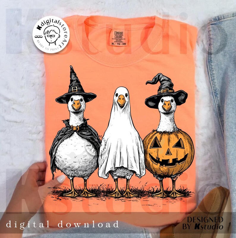 May include: Orange Comfort Colors sweatshirt featuring three geese in Halloween costumes: a witch, a ghost, and a jack-o'-lantern. The phrase "digital download" is at the bottom. The design is by Kstudio.