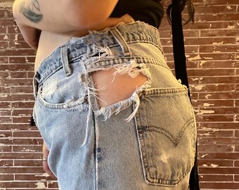 amazing vintage 80s thrashed levi’s light wash orange tab jeans with a bite in the side