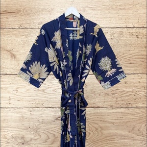 Könnte beinhalten: Eine marineblaue Robe mit Blumendruck. Die Robe hat lange Ärmel und einen Bindegürtel.