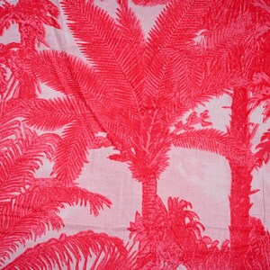 Peut inclure: Tissu rose et blanc avec un motif répété de palmiers. Le tissu a un aspect texturé et tissé.