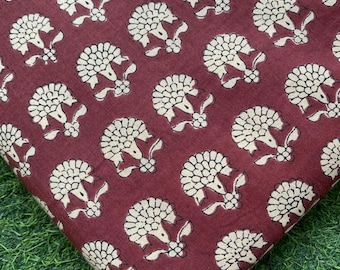 May include: A close-up of a maroon fabric with a white floral pattern. The fabric has a subtle texture and a repeating pattern of stylized flowers.