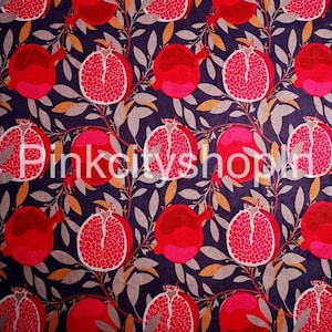 May include: A seamless fabric pattern featuring a repeating design of red pomegranates with white seeds on a dark purple background with brown and grey leaves.
