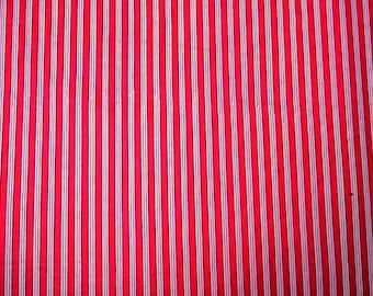 May include: Red and white striped fabric with a vertical pattern. The fabric has a smooth texture.