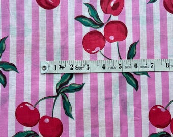 May include: Pink and white striped fabric with a repeating pattern of red cherries with green leaves. The fabric is measured with a ruler that reads "COBB" and "FIBER MESH COATED".