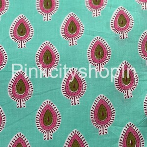 Può includere: Tessuto turchese con un motivo ripetuto di forme a paisley rosa e verde. Il tessuto ha una texture sottile.