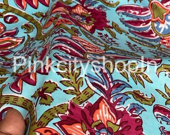 May include: Close-up of a turquoise fabric with a floral print. The fabric features a repeating pattern of pink, orange, and green flowers. The fabric is soft and flowing.