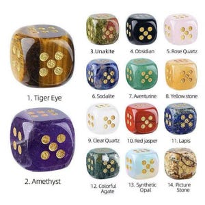 May include: A collection of fourteen gemstone dice, each with gold-colored dots. The dice are in various colors, including tiger eye, amethyst, unakite, obsidian, rose quartz, sodalite, aventurine, yellow stone, clear quartz, red jasper, lapis, colorful agate, synthetic opal, and picture stone.