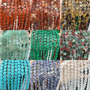 May include: Assortment of star-shaped gemstone beads in various colours, including green, blue, red, brown, and white. The beads are strung together in strands, creating a colourful and eye-catching display.
