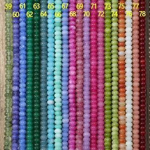 Puede incluir: Una colección de veinte hilos verticales de cuentas redondas en un espectro de colores, cada uno etiquetado con los números del 59 al 78. Las cuentas muestran varios tonos de verde, azul, rosa, morado, amarillo, naranja, blanco y rojo oscuro.