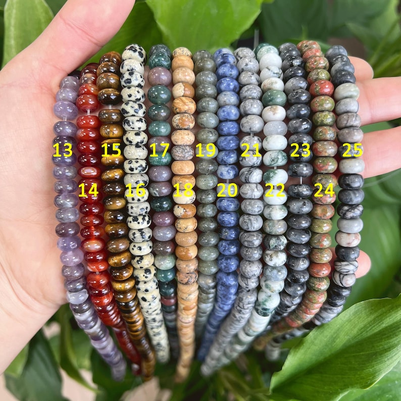 May include: A collection of 12 strands of round gemstone beads, each strand numbered 13-25. The beads are various colors, including red, brown, green, blue, and gray.