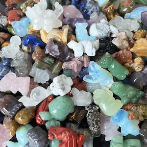 May include: A collection of small, hand-carved animal figurines made from various types of polished stones. The figurines are in a variety of colors, including green, blue, red, white, and brown. The figurines are all different sizes and shapes, and some have intricate details.
