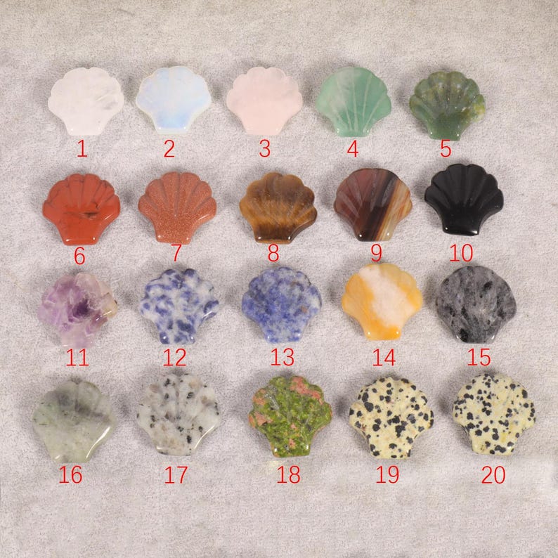 May include: A collection of twenty seashell-shaped gemstones in various colors and patterns. The gemstones include white, blue, pink, green, red, brown, black, purple, and speckled designs. Each stone is numbered from 1 to 20.