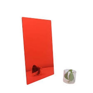 Può includere: Uno specchio rettangolare rosso è appoggiato a una superficie, riflettendo una vista parziale di un piccolo oggetto. Un bicchiere trasparente con foglie verdi è in primo piano. Le dimensioni dello specchio non sono visibili.