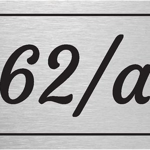 May include: A silver metal house number plaque with black lettering. The number is 62/a.
