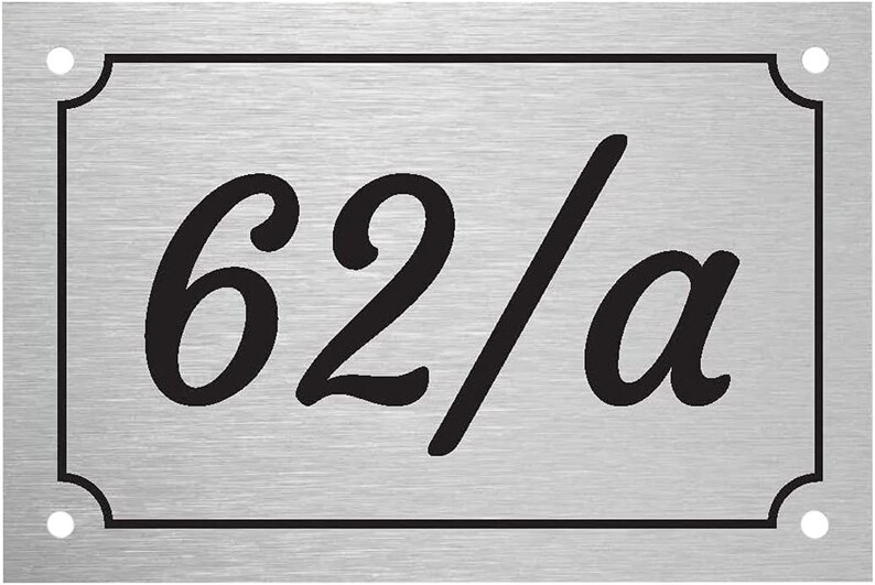 May include: A silver metal house number plaque with black lettering. The number is 62/a.