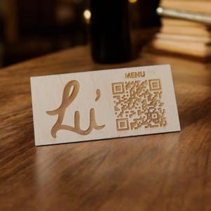 May include: A wooden sign with the word "Li" in cursive script and a QR code labeled "MENU".
