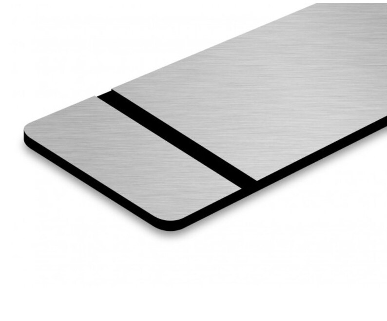 May include: A brushed silver metal sign with a black border. The sign is rectangular and has a slight bevel on the edges.